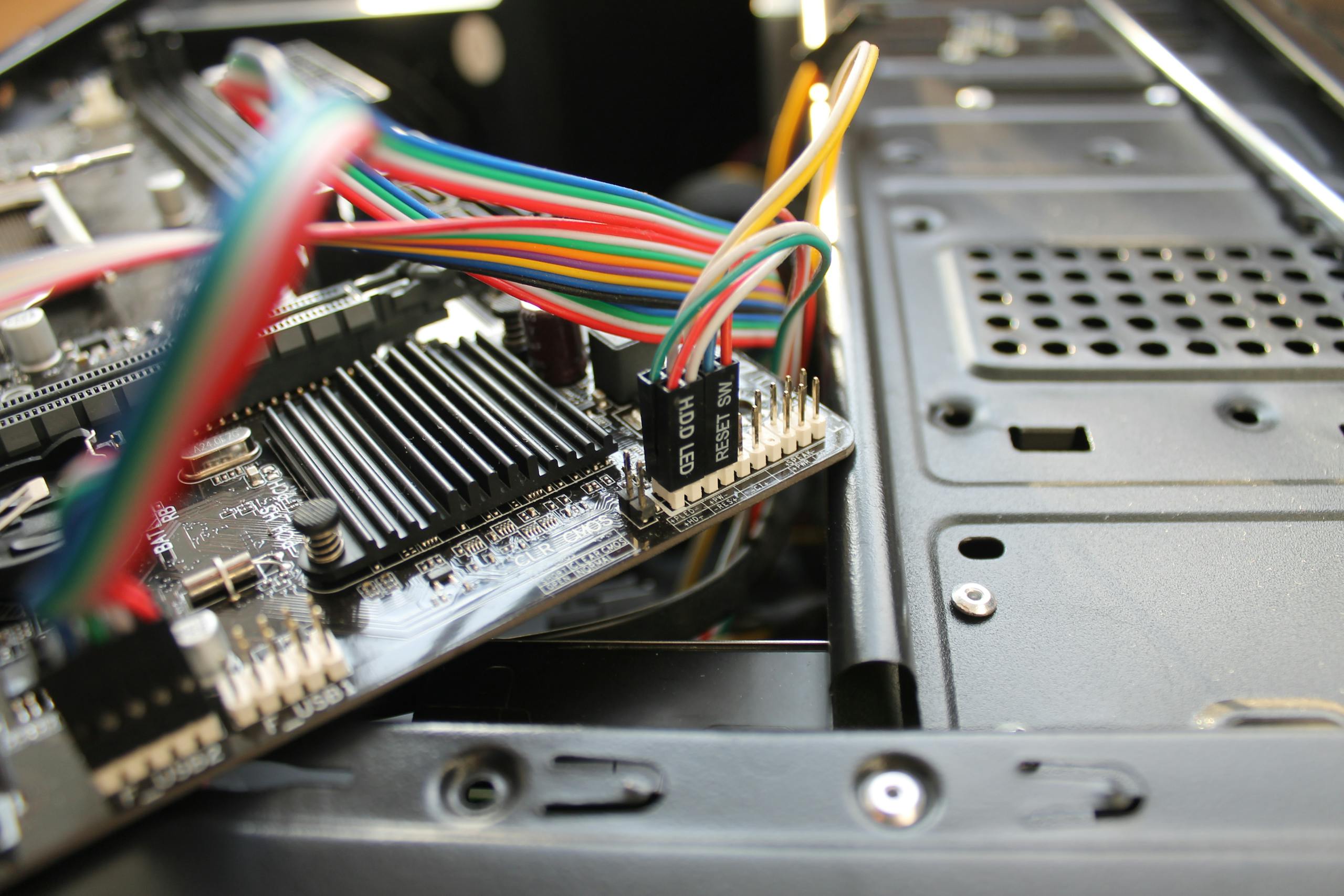 Close-up view of a motherboard with colorful wires and electronic components, showcasing intricate details.